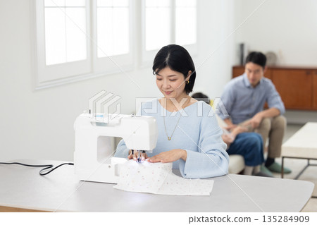 一位中年婦女在客廳縫紉 135284909