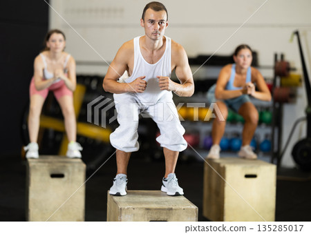 Young man training with crossfit box Young man training with crossfit box 135285017