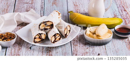 Sweet rolls with chocolate and banana on a plate on the table web banner Sweet rolls with chocolate and banana on a plate on the table web banner 135285035