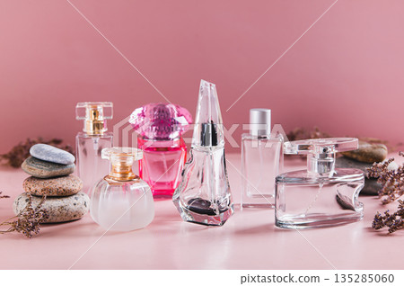 A beautiful arrangement of perfume bottles in pink tones on a table A beautiful arrangement of perfume bottles in pink tones on a table 135285060