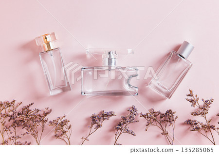 Close up of arrangement of perfume bottles in pink tones on a table top view Close up of arrangement of perfume bottles in pink tones on a table top view 135285065