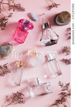 Perfume bottles, dried flowers and stones on a pink background top and vertical view 135285066