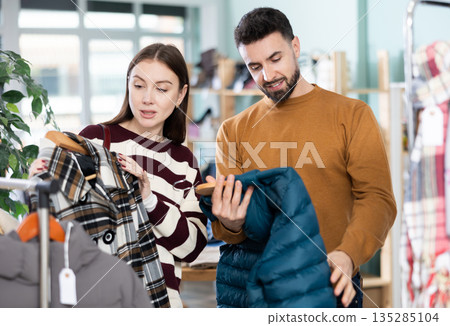 In store, couple customer choose something outwear clothes In store, couple customer choose something outwear clothes 135285104