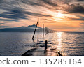 Sunset over the seabed road with a woman and a child 135285164