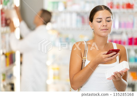 Young girl customer scanning QR of medical product Young girl customer scanning QR of medical product 135285168