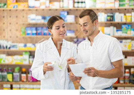 Man client with prescription should contact girl pharmacist for help, takes box remedy Man client with prescription should contact girl pharmacist for help, takes box remedy 135285175