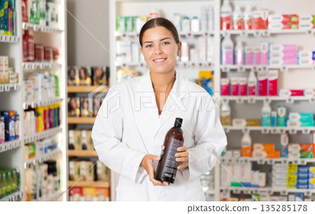 Young female pharmacist offering shampoo Young female pharmacist offering shampoo 135285178