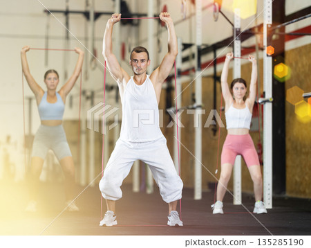 Young man exercising with elastic band 135285190