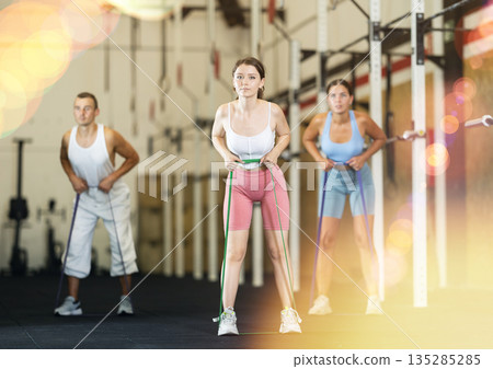 Young woman exercising with elastic band 135285285