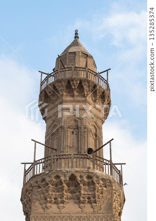 Historic Qalawun Complex in Cairo, featuring intricate architecture, tall minarets, and domes under a blue sky with clouds. A significant cultural landmark on Al-Muizz Street. Historic Qalawun Complex in Cairo, featuring intricate architecture, tall minarets, and domes under a blue sky with clouds. A significant cultural landmark on Al-Muizz Street. 135285374