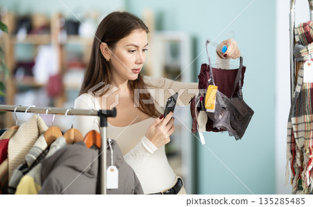 Young woman scans qr code of bra in store Young woman scans qr code of bra in store 135285485