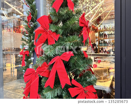 Christmas tree decorated with red bows 135285673
