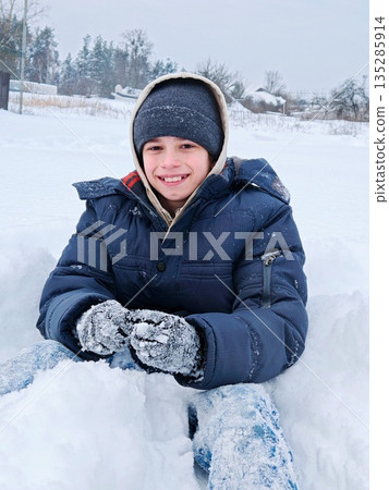 Portrait of a happy young boy outdoors in winter wearing winter clothes Portrait of a happy young boy outdoors in winter wearing winter clothes 135285914