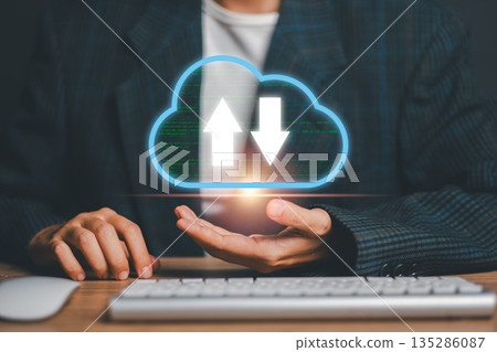 Businessman in suit holding a digital cloud icon with data transfer arrows, symbolizing cloud computing and data management. 135286087