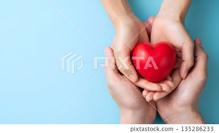 Hands Holding a Red Heart on a Blue Background Symbolizing Love Hands Holding a Red Heart on a Blue Background Symbolizing Love 135286233