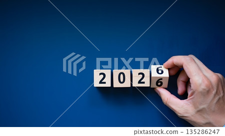 Hand Changing Number on Wooden Cubes for Year 2026 Celebration 135286247