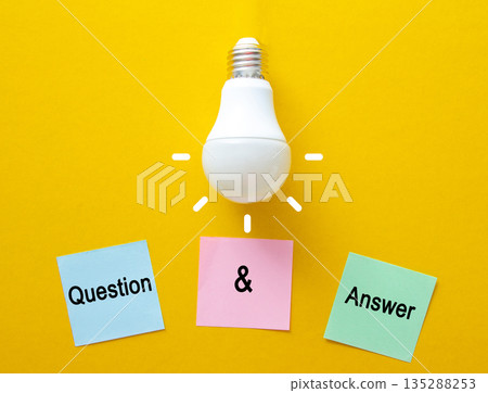 Light bulb illuminating question and answer sticky notes, symbolizing problem solving and new ideas 135288253