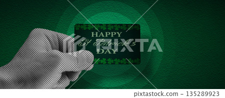 St. Patrick's Day calendar, March 17. Halftone collage: a hand holding a St. Patrick's Day greeting card. A symbol of good luck and success. St. Patrick's Day calendar, March 17. Halftone collage: a hand holding a St. Patrick's Day greeting card. A symbol of good luck and success. 135289923