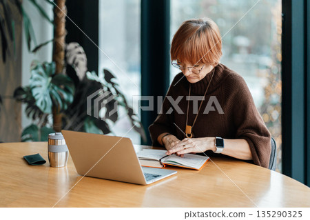 Business, woman and portrait of a mature ceo proud of her startup company success in a corporate office. Female write the notes at notebook Business, woman and portrait of a mature ceo proud of her startup company success in a corporate office. Female write the notes at notebook 135290325