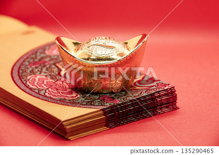Stack of red and yellow packets arranged neatly with golden ingot symbolizing generosity and Lunar New Year customs. Stack of red and yellow packets arranged neatly with golden ingot symbolizing generosity and Lunar New Year customs. 135290465