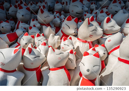 Close focus on the fox dolls in white and red color touching the sunlight. 135290923