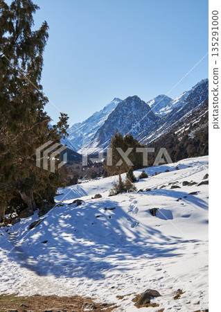 Snow covered mountain landscape with footprints in a valley. Winter scene Snow covered mountain landscape with footprints in a valley. Winter scene 135291000