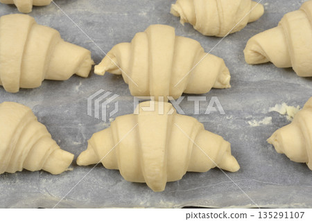 Raw crescent rolls on baking paper 135291107