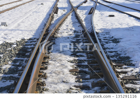 Snowy railway tracks and metal switches 135291116