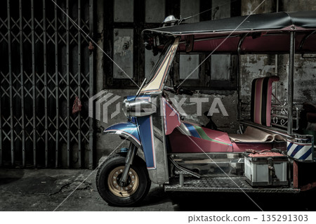 Famous blue Tuk Tuk, The front of thai traditional taxi with an old ancient wall behind. 135291303