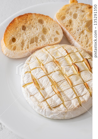 Baked camembert with toasted ciabatta garlic and rosemary garnish Baked camembert with toasted ciabatta garlic and rosemary garnish 135291350