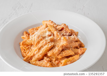 Penne pasta in creamy ricotta tomato sauce with grated parmesan cheese 135291357