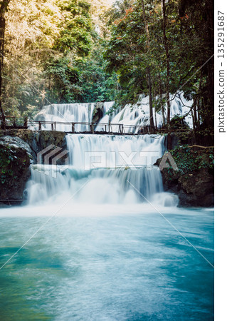 Cascade waterfalls with blue water and wooden bridge in Sulawesi Cascade waterfalls with blue water and wooden bridge in Sulawesi 135291687