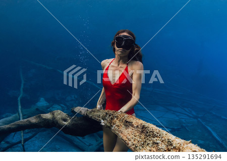 Female freediver posing underwater lake in blue freshwater 135291694