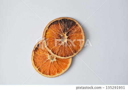 Two dehydrated orange slices stack against a simple white backdrop Two dehydrated orange slices stack against a simple white backdrop 135291931