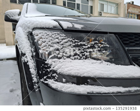 White snow coats the one side of the black car 135291938
