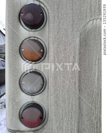 A dirty rear bumper and headlights on the white minibus 135291939