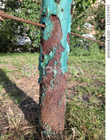 Metal corrosion. Old rusty cracked iron post with peeling blue paint 135291945