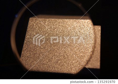 Sample of aluminum under magnifying glass with small grains,that froze very fast Sample of aluminum under magnifying glass with small grains,that froze very fast 135291970