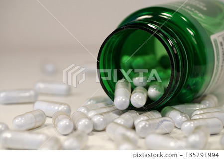 Overdose. Capsules with blue powder scattered on the table. Open green container Overdose. Capsules with blue powder scattered on the table. Open green container 135291994