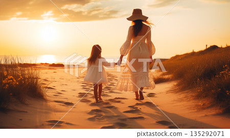 Mother walking with her child along a beach park at sunset 135292071