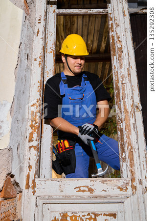 Maintenance technician organizing tools inside window frame Maintenance technician organizing tools inside window frame 135292308