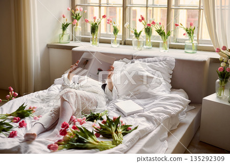 Peaceful waking scene featuring sunlit room decorated with tulips and soft spring atmosphere Peaceful waking scene featuring sunlit room decorated with tulips and soft spring atmosphere 135292309