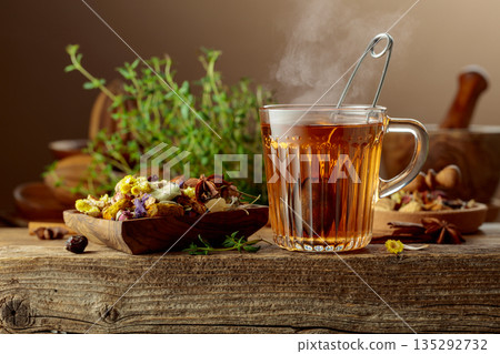 Herbal tea with ingredients on a old wooden table. 135292732