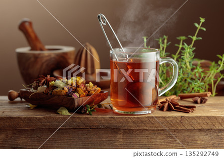 Herbal tea with ingredients on a old wooden table. 135292749