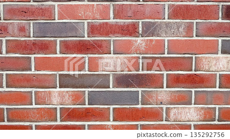 Detailed texture of a multicolored red and brown clinker brick wall with white mortar joints 135292756