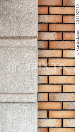 Modern architectural detail featuring a contrast between orange brickwork and grey textured plaster Modern architectural detail featuring a contrast between orange brickwork and grey textured plaster 135292759