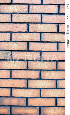 Textured brick wall background with orange clay bricks, dark mortar joints, and rustic urban style. 135292761