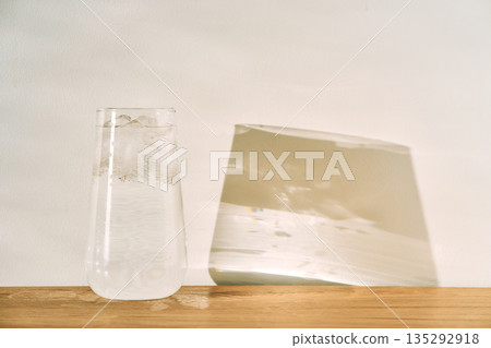 Glass of water with ice casting light reflections Glass of water with ice casting light reflections 135292918