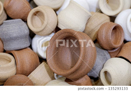 A variety of small toy clay pots of various sizes and colors 135293133
