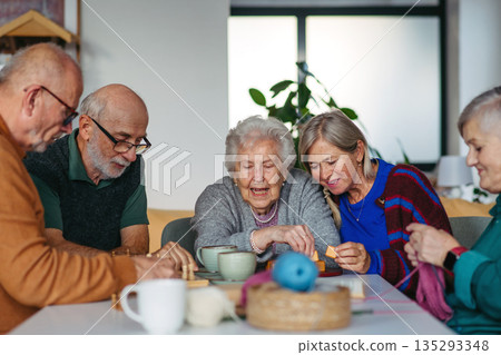 Group of senior people enjoying different activities in community center. 135293348